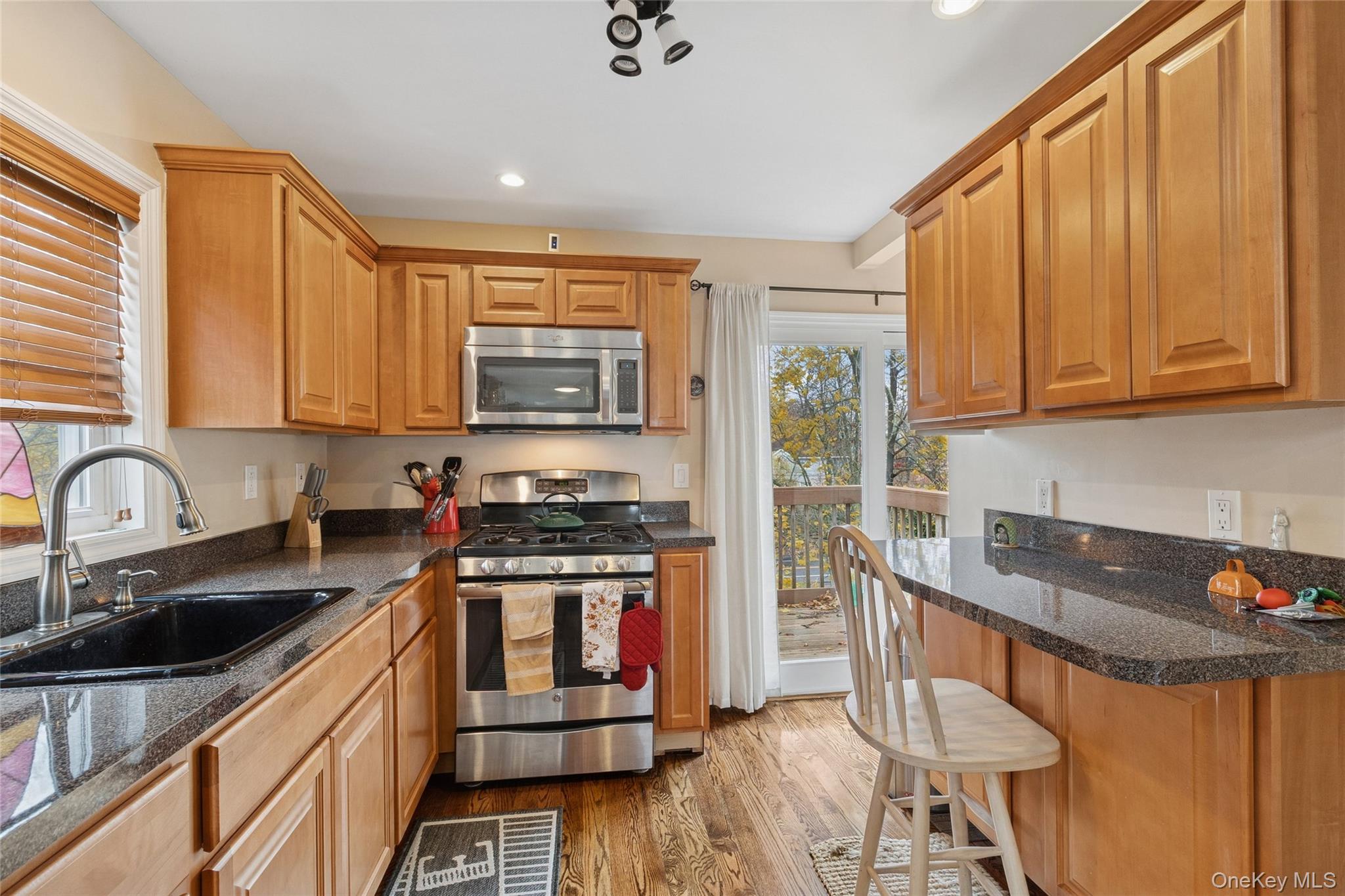 31 Amityville Road Sound Beach, NY 11789 - Photo 22 of 33 a kitchen with stainless steel appliances granite countertop a stove a sink dishwasher and a microwave oven with wooden cabinets