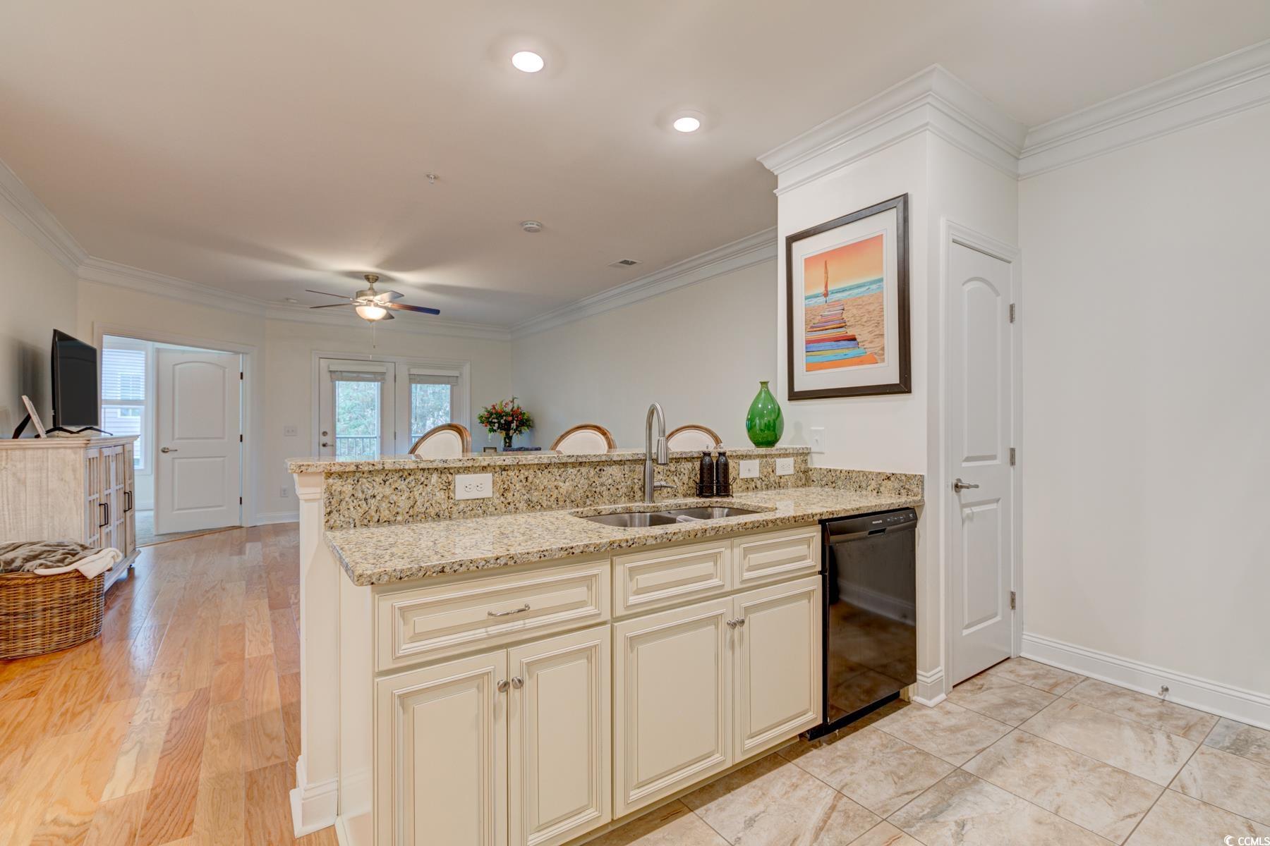 130 Puffin Drive, Unit 2B Pawleys Island, SC 29585 - Photo 12 of 34 Kitchen with a peninsula, light stone countertops, a ceiling fan, crown molding, and dishwasher