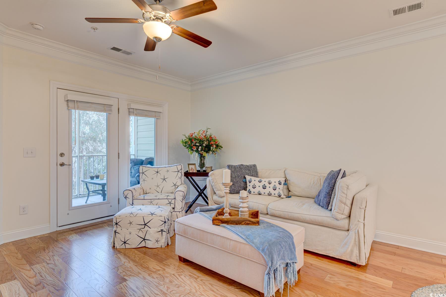 130 Puffin Drive, Unit 2B Pawleys Island, SC 29585 - Photo 17 of 34 Living room with light wood-style flooring, crown molding, and ceiling fan