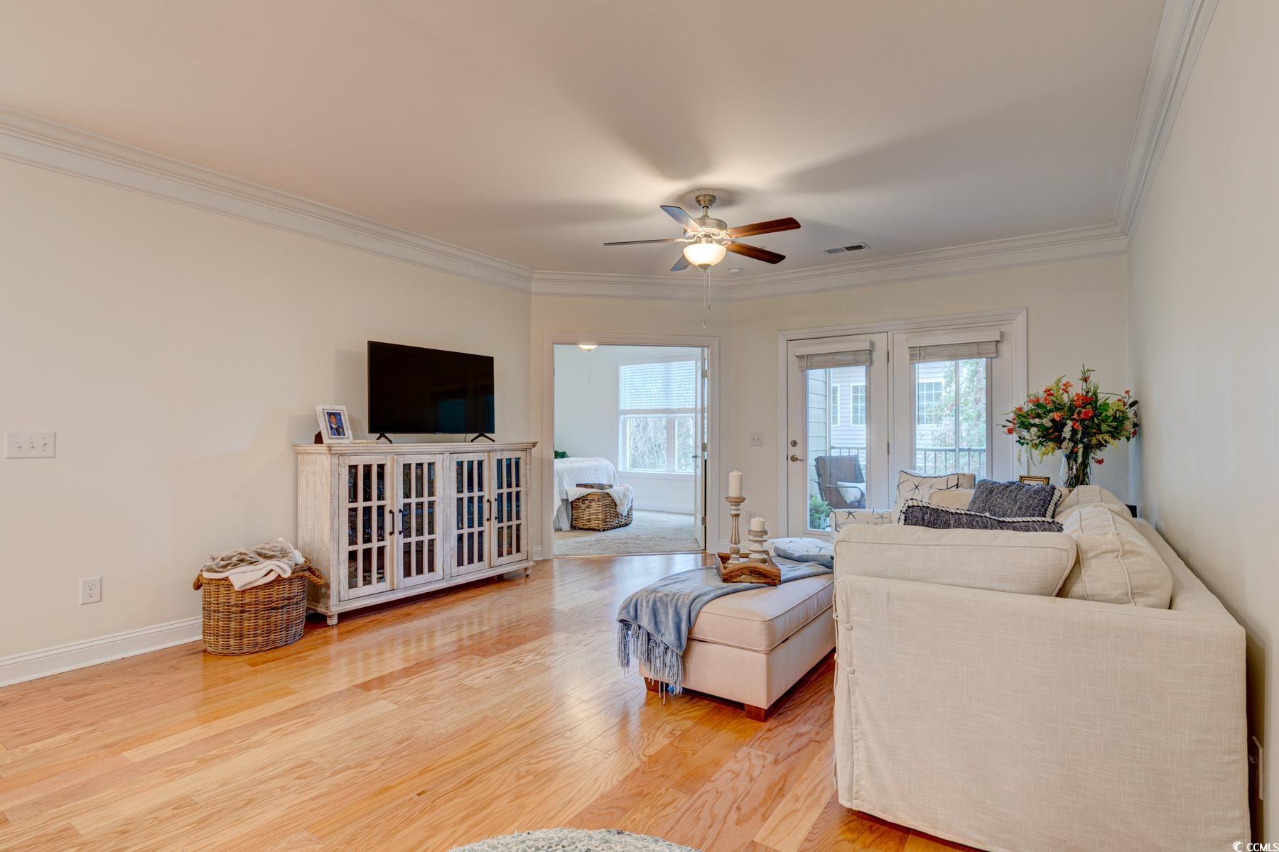 130 Puffin Drive, Unit 2B Pawleys Island, SC 29585 - Photo 18 of 34 Living room with light wood finished floors, ornamental molding, and a ceiling fan