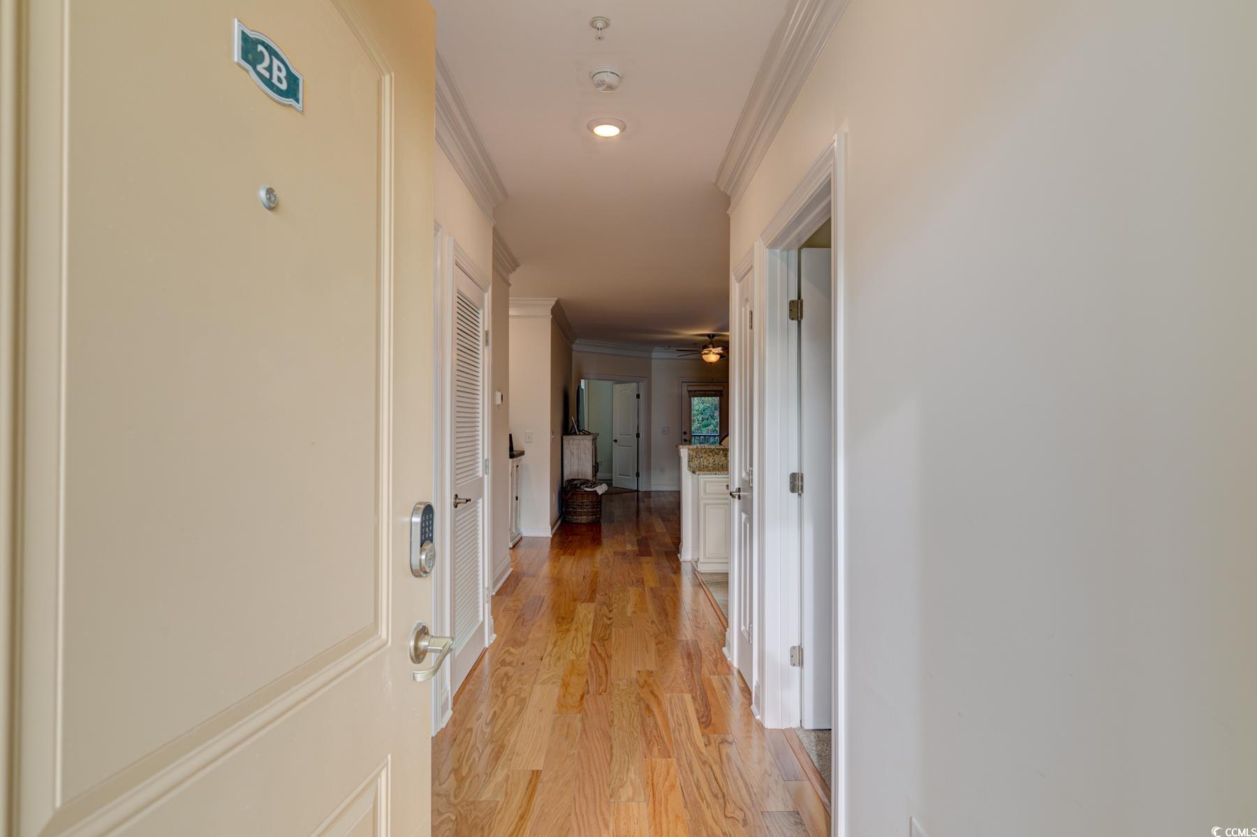 130 Puffin Drive, Unit 2B Pawleys Island, SC 29585 - Photo 3 of 34 Hallway featuring crown molding and light wood-type flooring