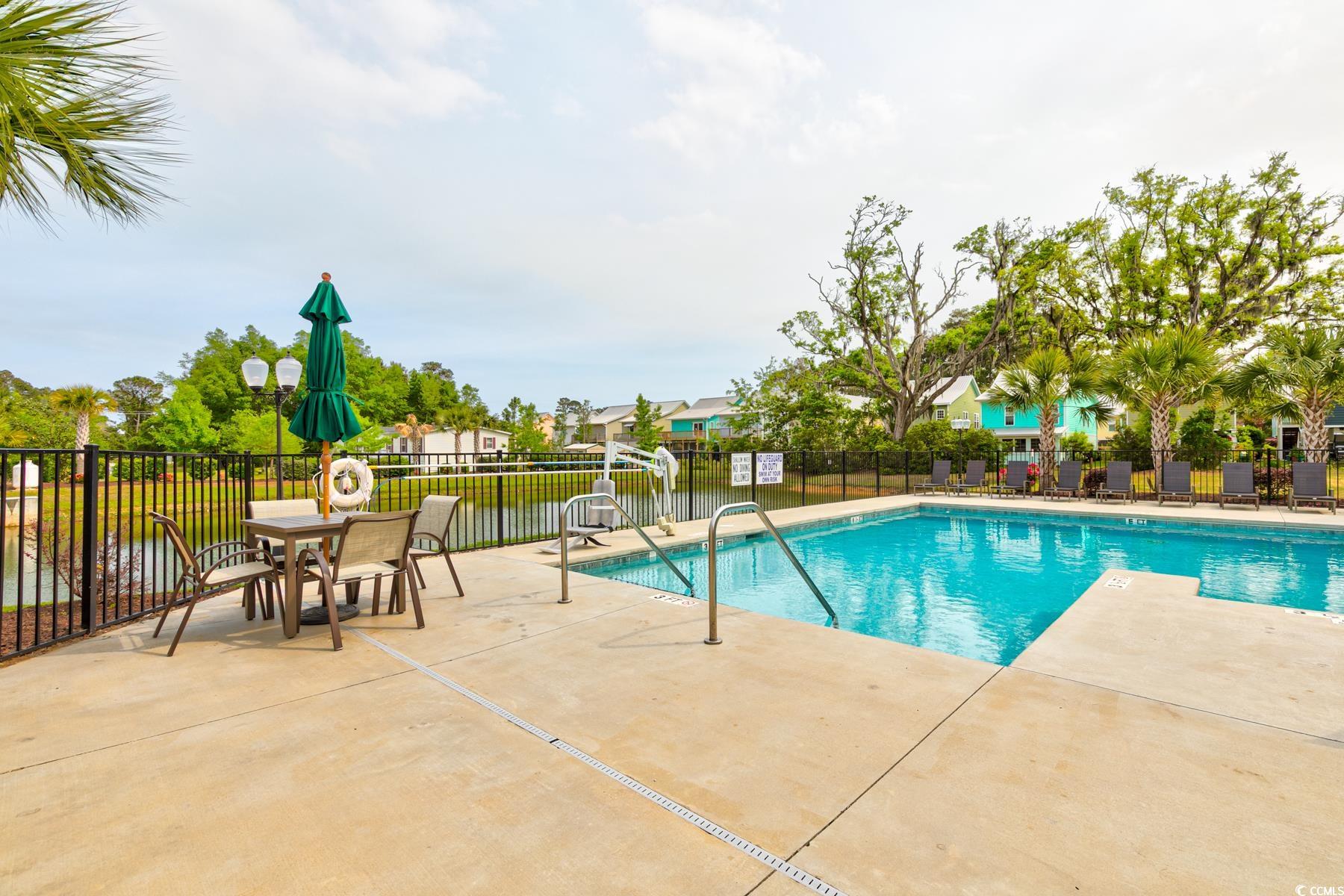 130 Puffin Drive, Unit 2B Pawleys Island, SC 29585 - Photo 32 of 34 Community pool with a patio area and a water view