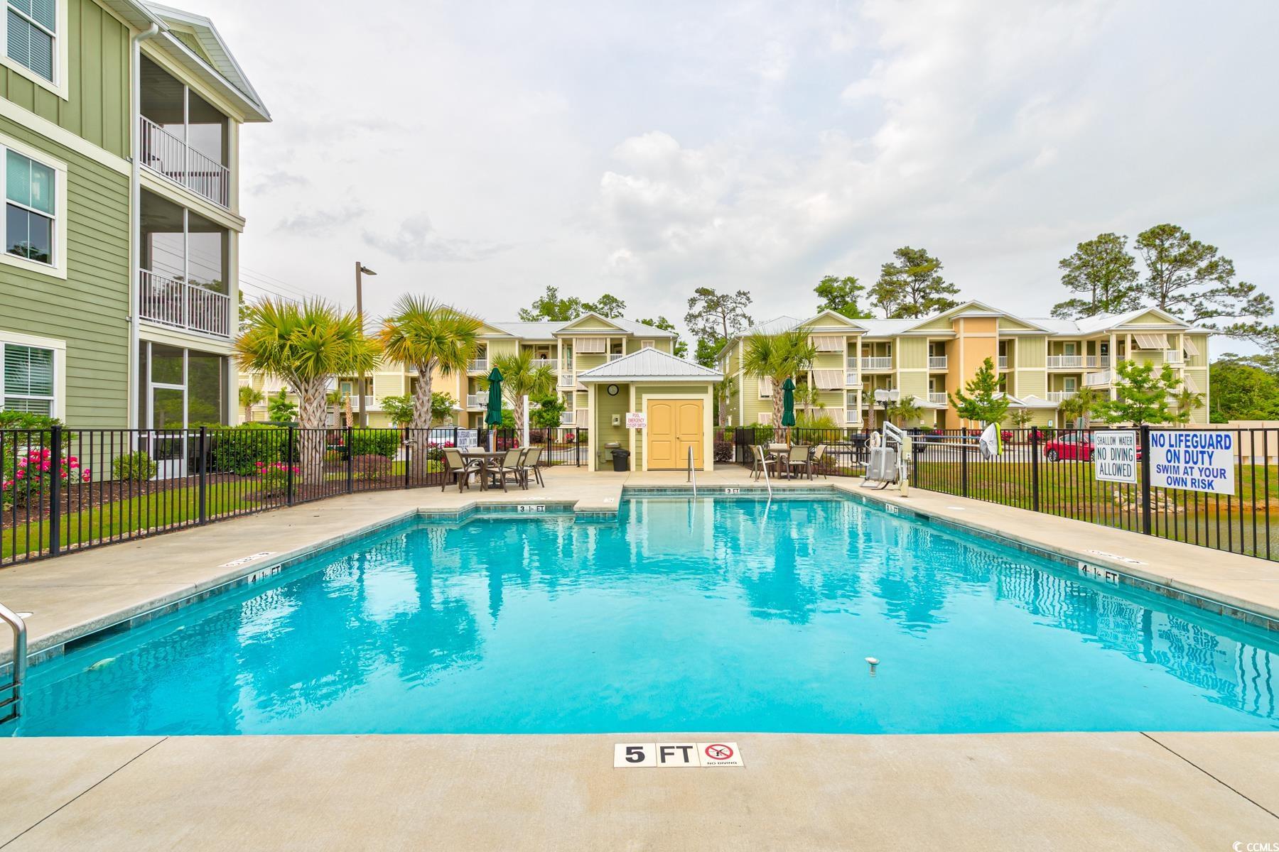 130 Puffin Drive, Unit 2B Pawleys Island, SC 29585 - Photo 33 of 34 Community pool featuring a patio and a residential view