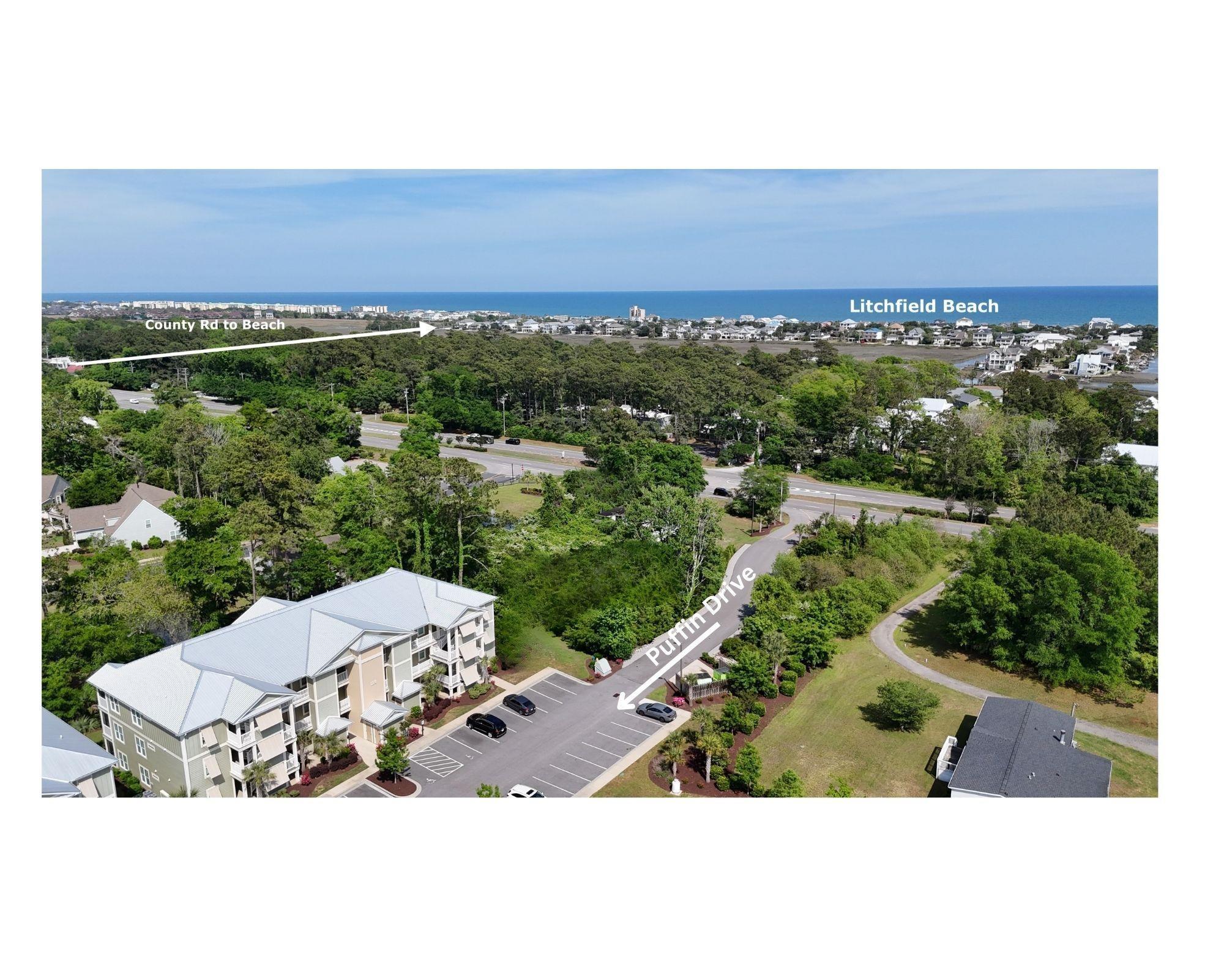 130 Puffin Drive, Unit 2B Pawleys Island, SC 29585 - Photo 34 of 34 Bird's eye view of a nearby body of water and a tree filled landscape