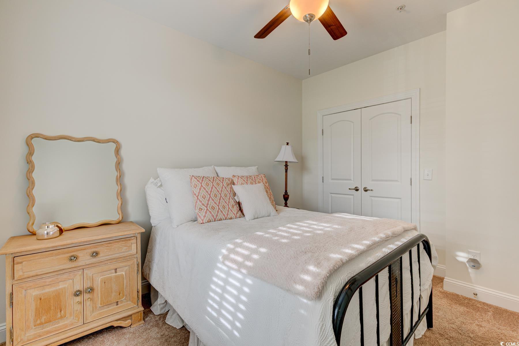 130 Puffin Drive, Unit 2B Pawleys Island, SC 29585 - Photo 5 of 34 Bedroom featuring light carpet, a closet, and a ceiling fan