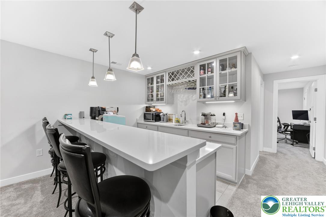 3952 Orth Street Bethlehem, PA 18020 - Photo 41 of 60 An inviting basement bar features sleek countertops and elegant pendant lighting.