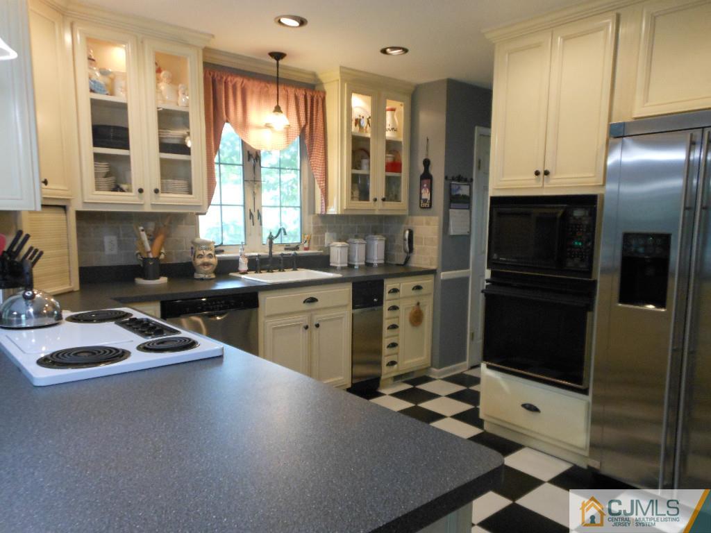 421 Ridge Road Dayton, NJ 08810 - Photo 2 of 17 a kitchen with stainless steel appliances granite countertop a sink stove and refrigerator