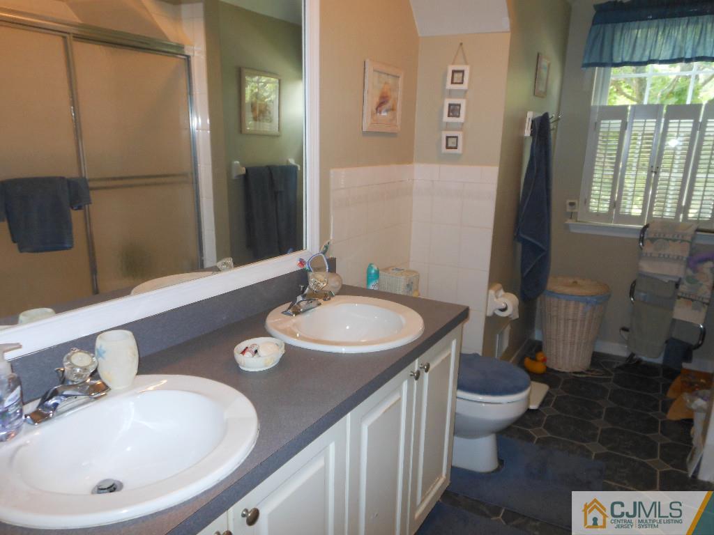 421 Ridge Road Dayton, NJ 08810 - Photo 11 of 17 a bathroom with a sink and mirror with toilet