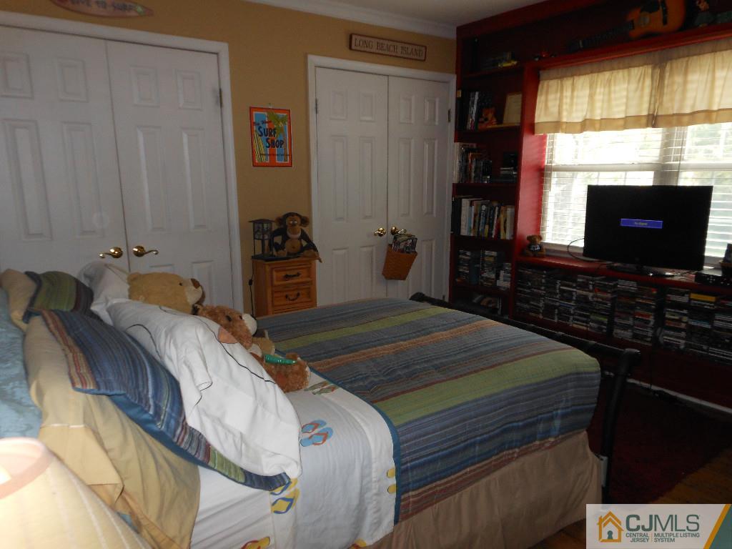 421 Ridge Road Dayton, NJ 08810 - Photo 12 of 17 a bedroom with a bed and a flat tv screen on dresser