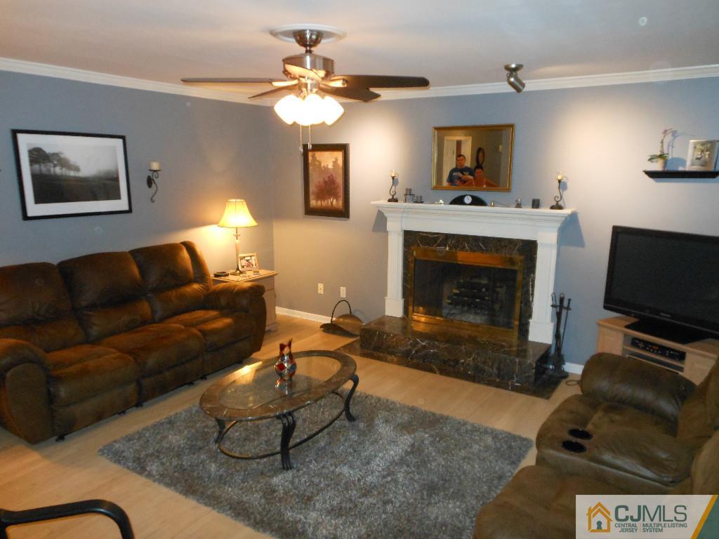 421 Ridge Road Dayton, NJ 08810 - Photo 5 of 17 a living room with furniture a fireplace and a flat screen tv