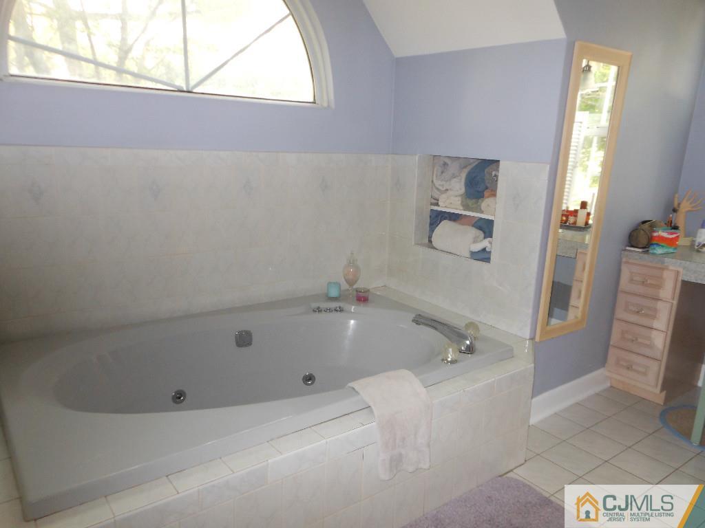 421 Ridge Road Dayton, NJ 08810 - Photo 9 of 17 a bathroom with a tub a window and a shower