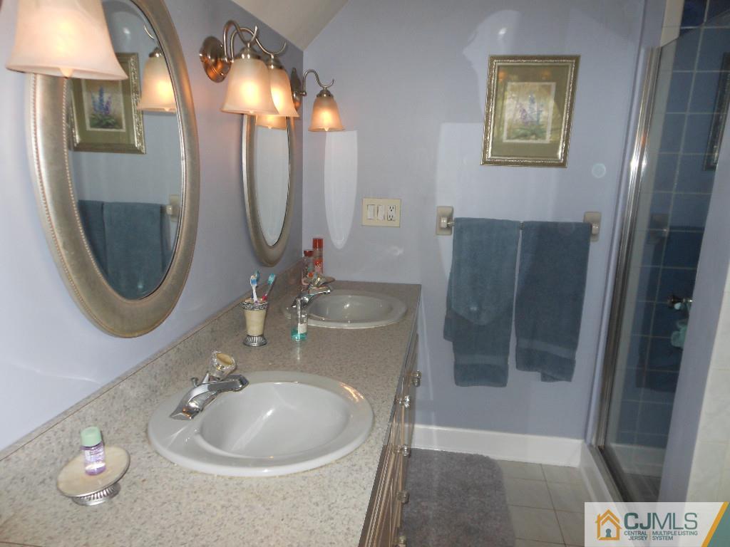 421 Ridge Road Dayton, NJ 08810 - Photo 10 of 17 a bathroom with a sink a toilet and a mirror