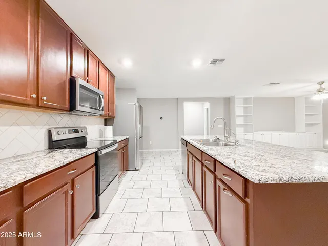 a large kitchen with stainless steel appliances granite countertop lots of counter top space