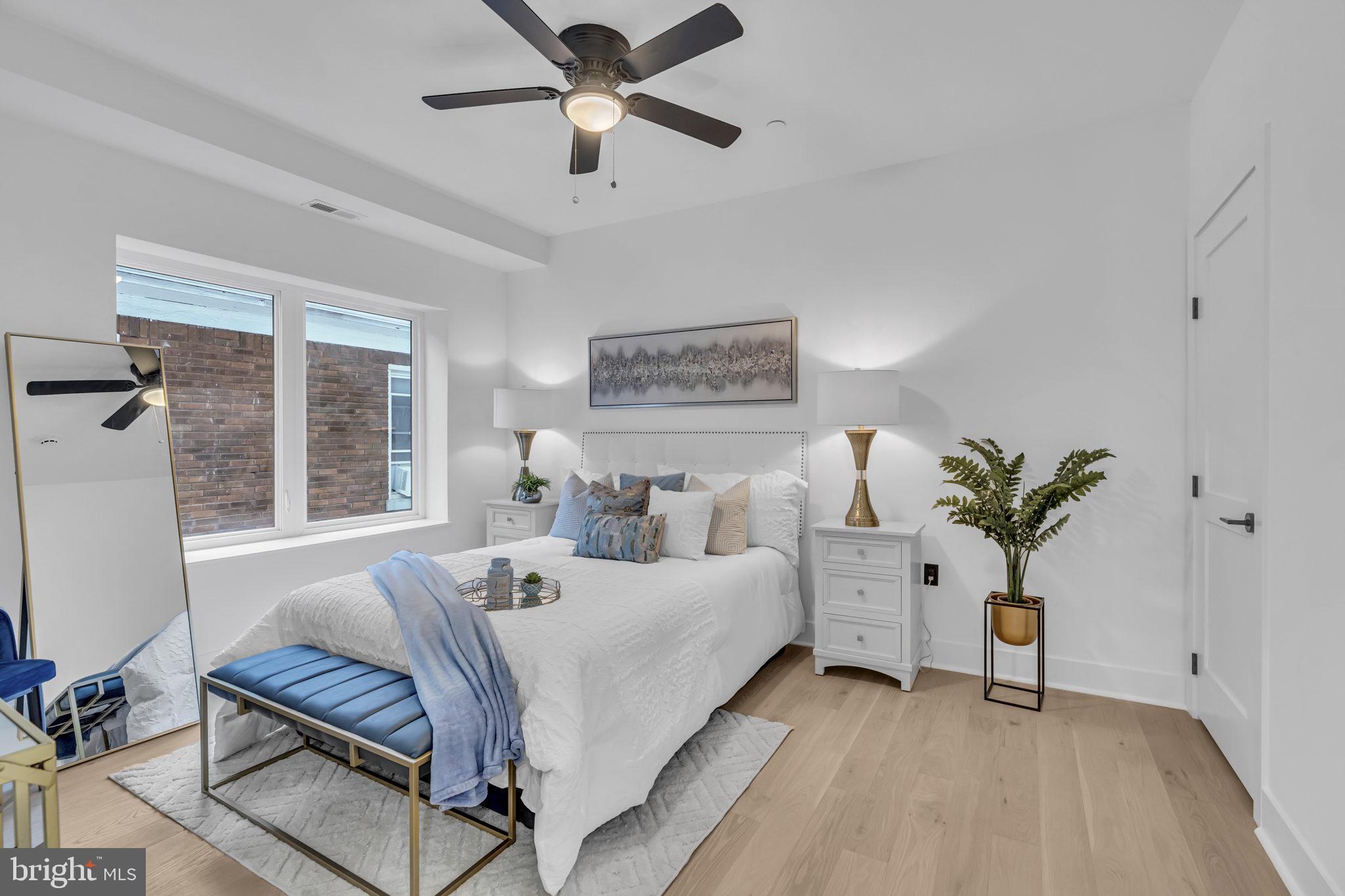 1103 Fern Street Northwest, Unit 301 Washington, DC 20012 - Photo 18 of 57 a bedroom with a large bed and a chandelier