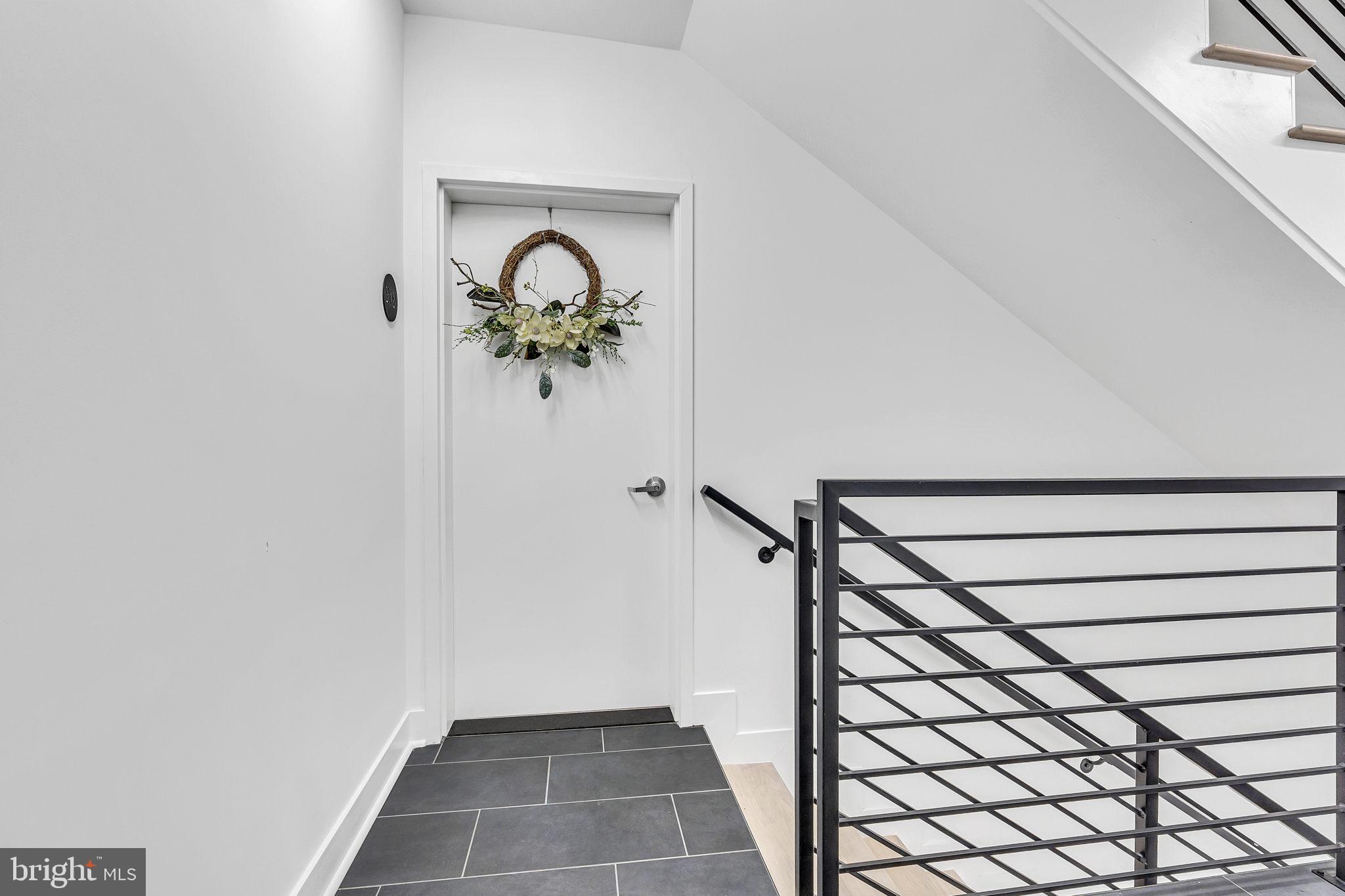 1103 Fern Street Northwest, Unit 301 Washington, DC 20012 - Photo 21 of 57 a view of a hallway with wooden floor and a potted plant