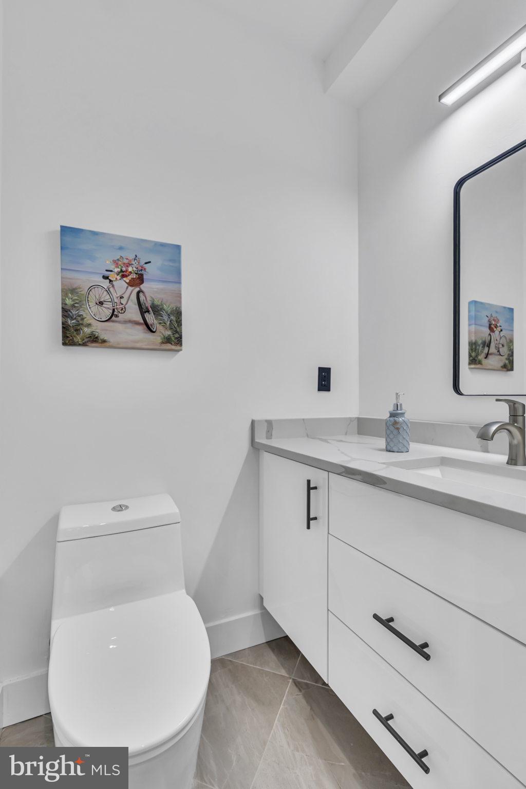 1103 Fern Street Northwest, Unit 301 Washington, DC 20012 - Photo 27 of 57 a bathroom with a toilet sink and mirror
