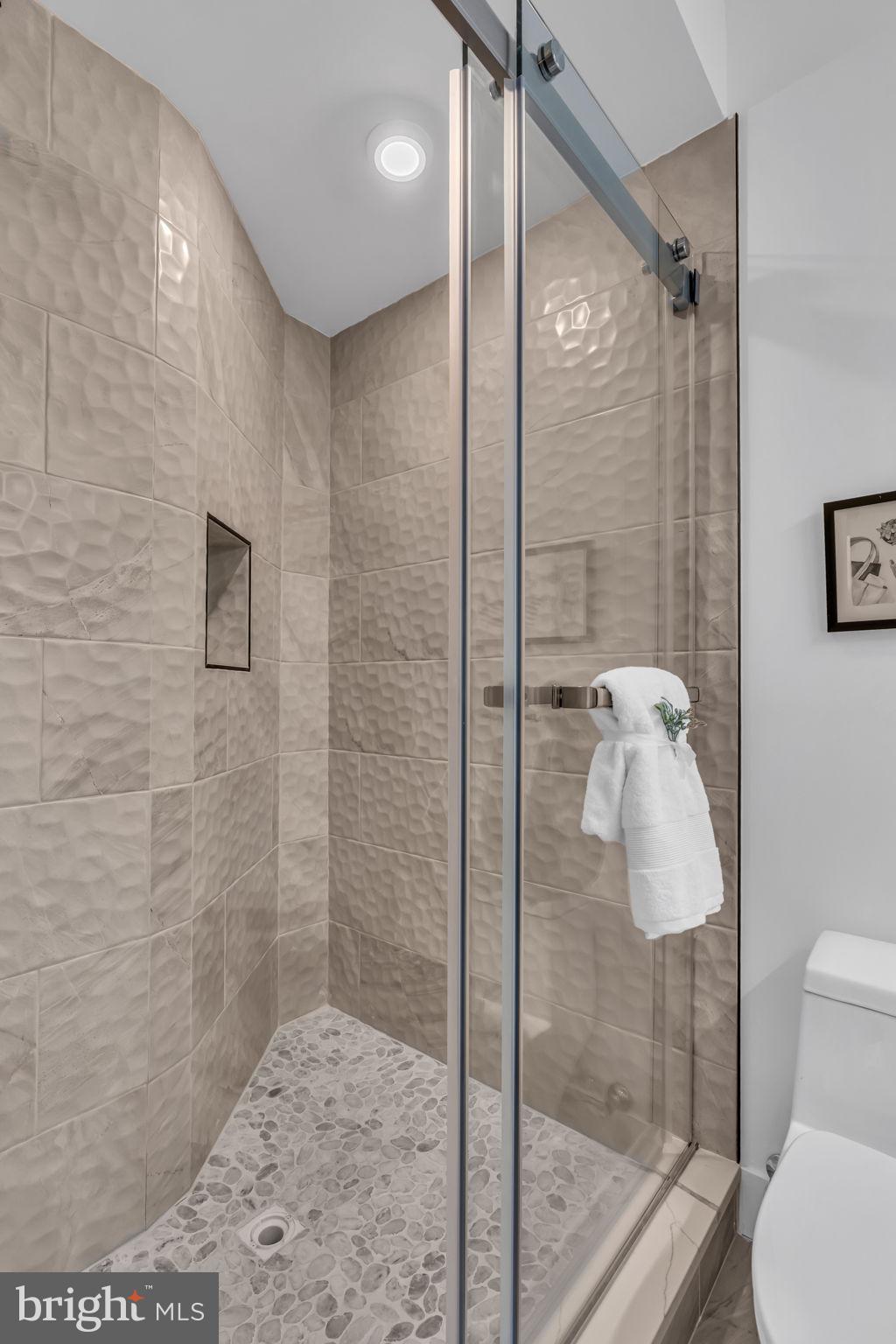 1103 Fern Street Northwest, Unit 301 Washington, DC 20012 - Photo 42 of 57 a bathroom with a shower and toilet