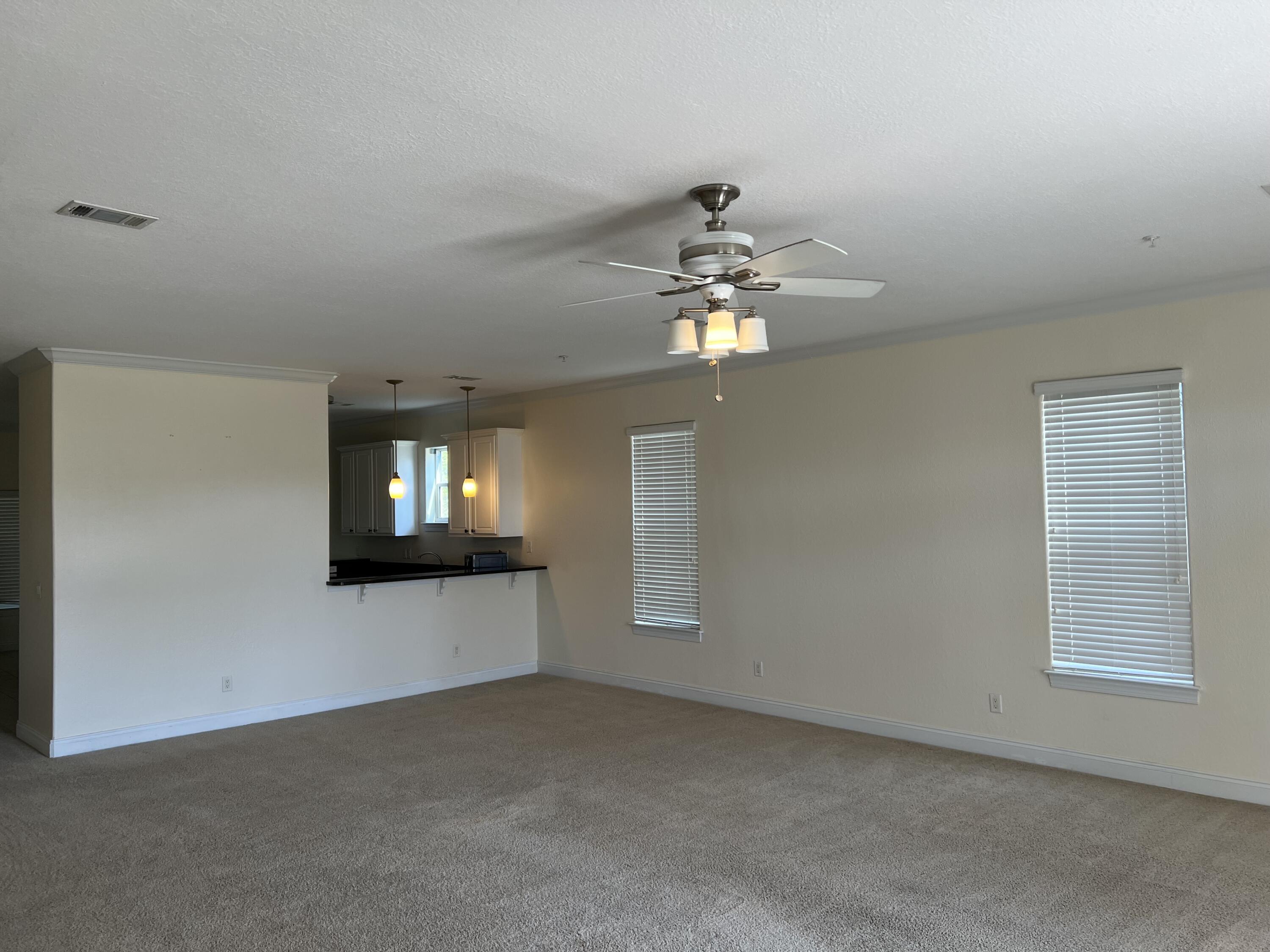 118 Spires Lane, Unit 5B Santa Rosa Beach, FL 32459 - Photo 5 of 28 a view of an empty room with a chandelier fan and a window