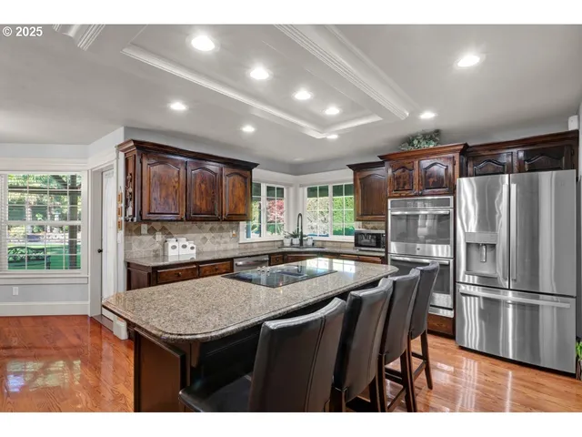 a kitchen with stainless steel appliances granite countertop a sink refrigerator and microwave