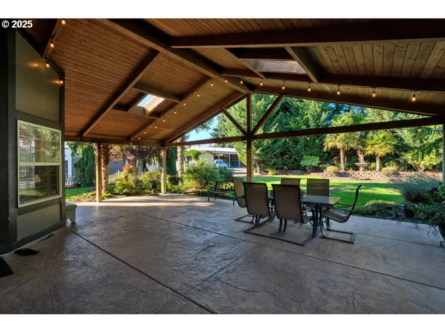 a view of a patio with table and chairs with wooden floor and fence