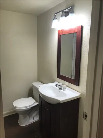 a bathroom with a sink mirror vanity and toilet