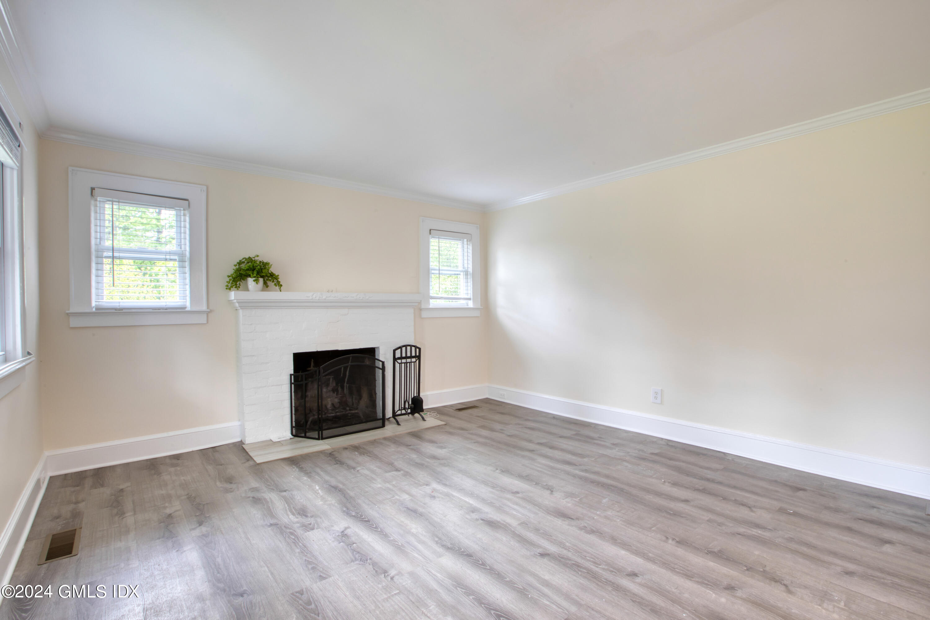 4 R Highview Avenue Old Greenwich, CT 06870 - Photo 7 of 21 an empty room with wooden floor fireplace and windows