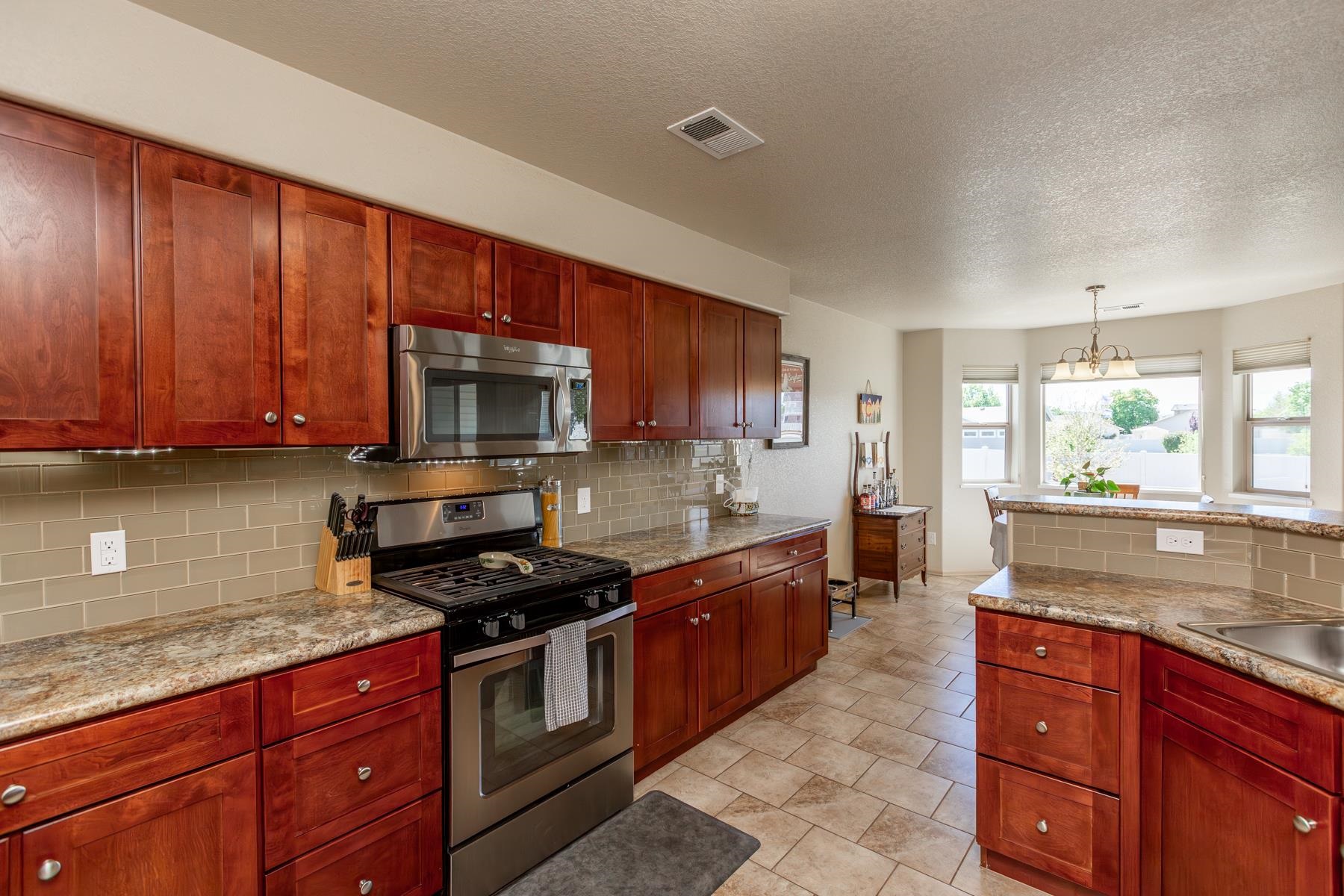 103 Red Rocks Street Fruita, CO 81521 - Photo 27 of 39 a kitchen with granite countertop wooden cabinets a stove top oven and granite counter tops