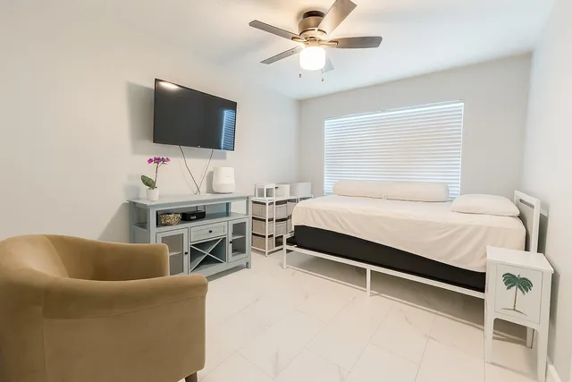 a bedroom with a bed and a flat screen tv