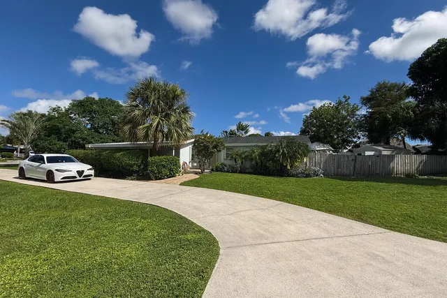 a house with green field in front of it