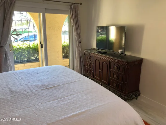 a bedroom with a bed and a flat screen tv