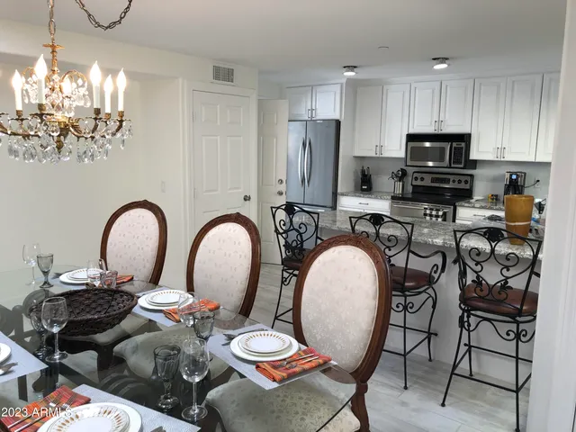 a kitchen with sink a stove and chairs