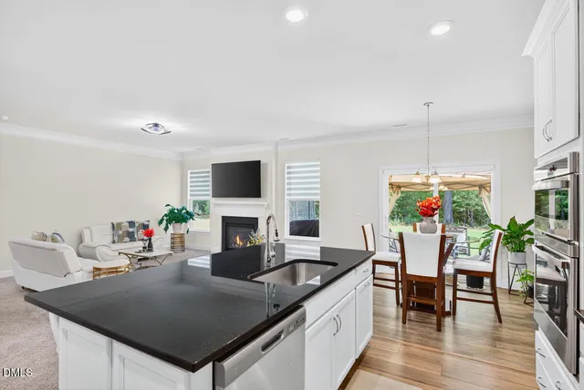 a living room with furniture a flat screen tv and kitchen view