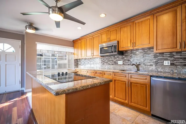 a kitchen with stainless steel appliances granite countertop a sink a stove cabinets counter space and a window