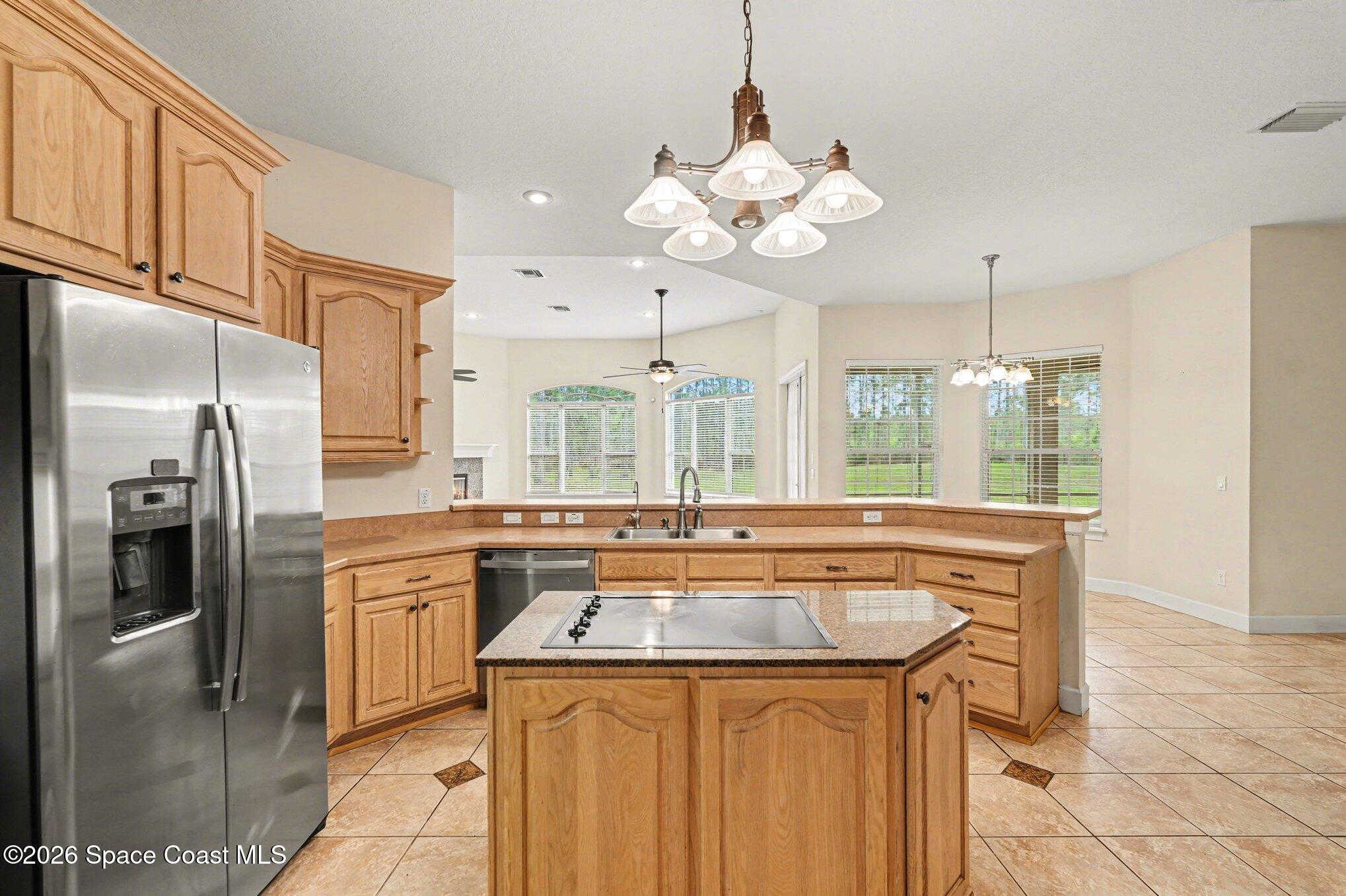 1399 Snapping Turtle Road Mims, FL 32754 - Photo 14 of 51 a kitchen with stainless steel appliances granite countertop a sink a refrigerator and a stove