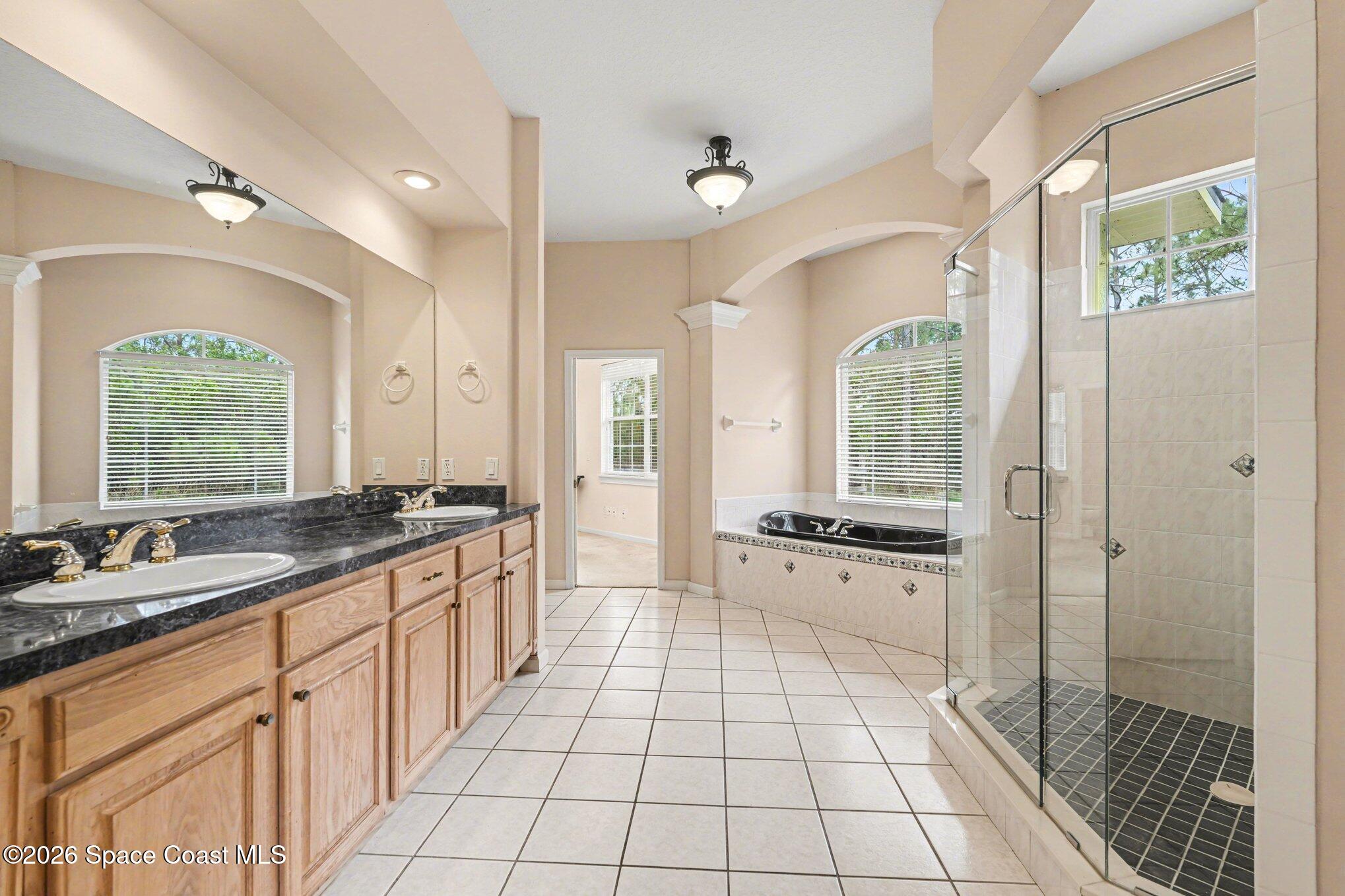 1399 Snapping Turtle Road Mims, FL 32754 - Photo 25 of 51 a large bathroom with a granite countertop tub a double vanity sink a mirror and a shower
