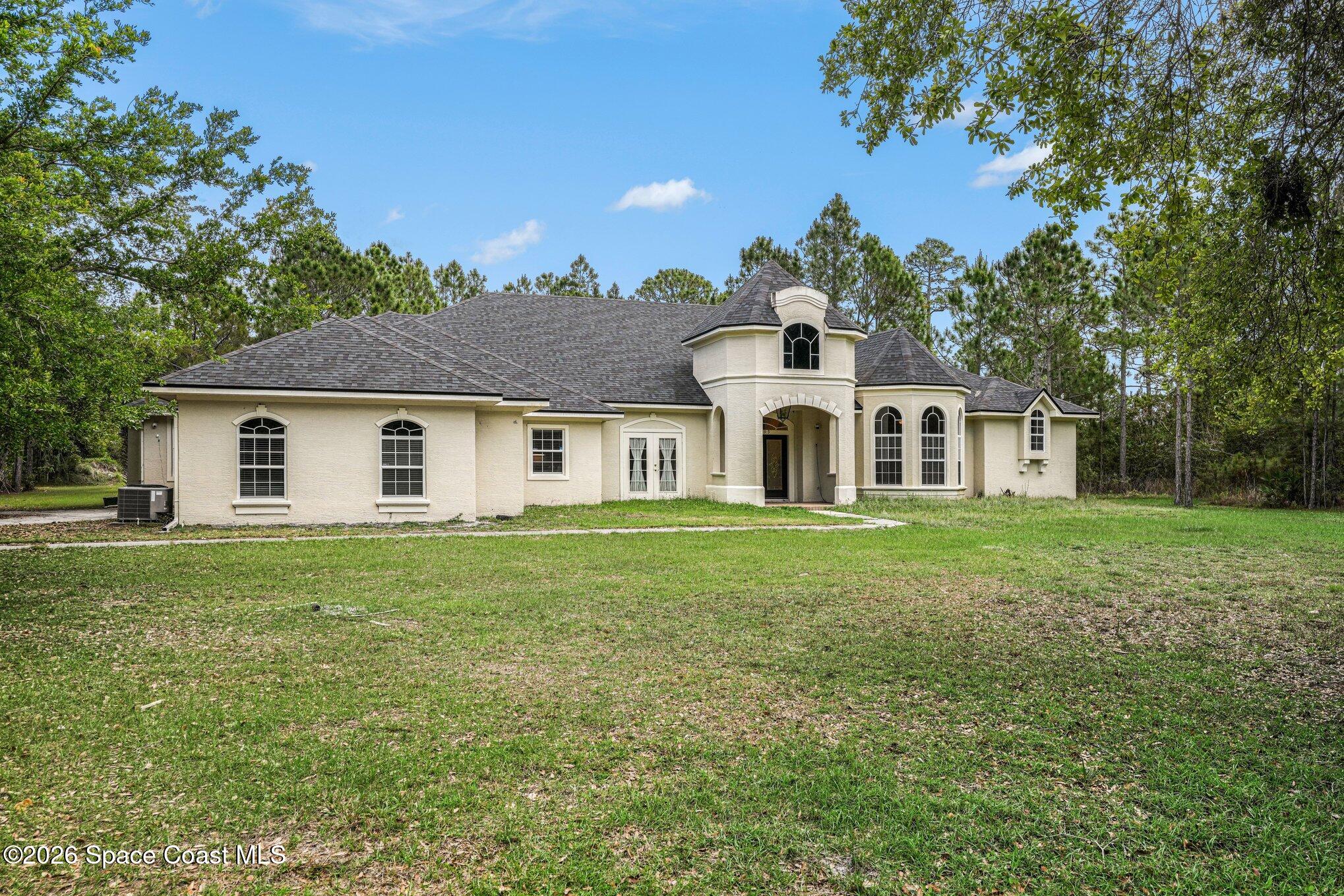 1399 Snapping Turtle Road Mims, FL 32754 - Photo 3 of 51 a view of a white house with a yard