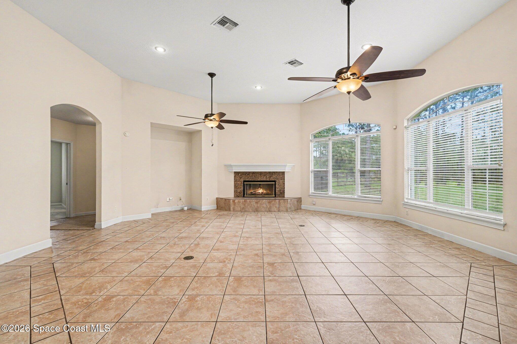 1399 Snapping Turtle Road Mims, FL 32754 - Photo 8 of 51 a view of an empty room with a fireplace and a chandelier fan