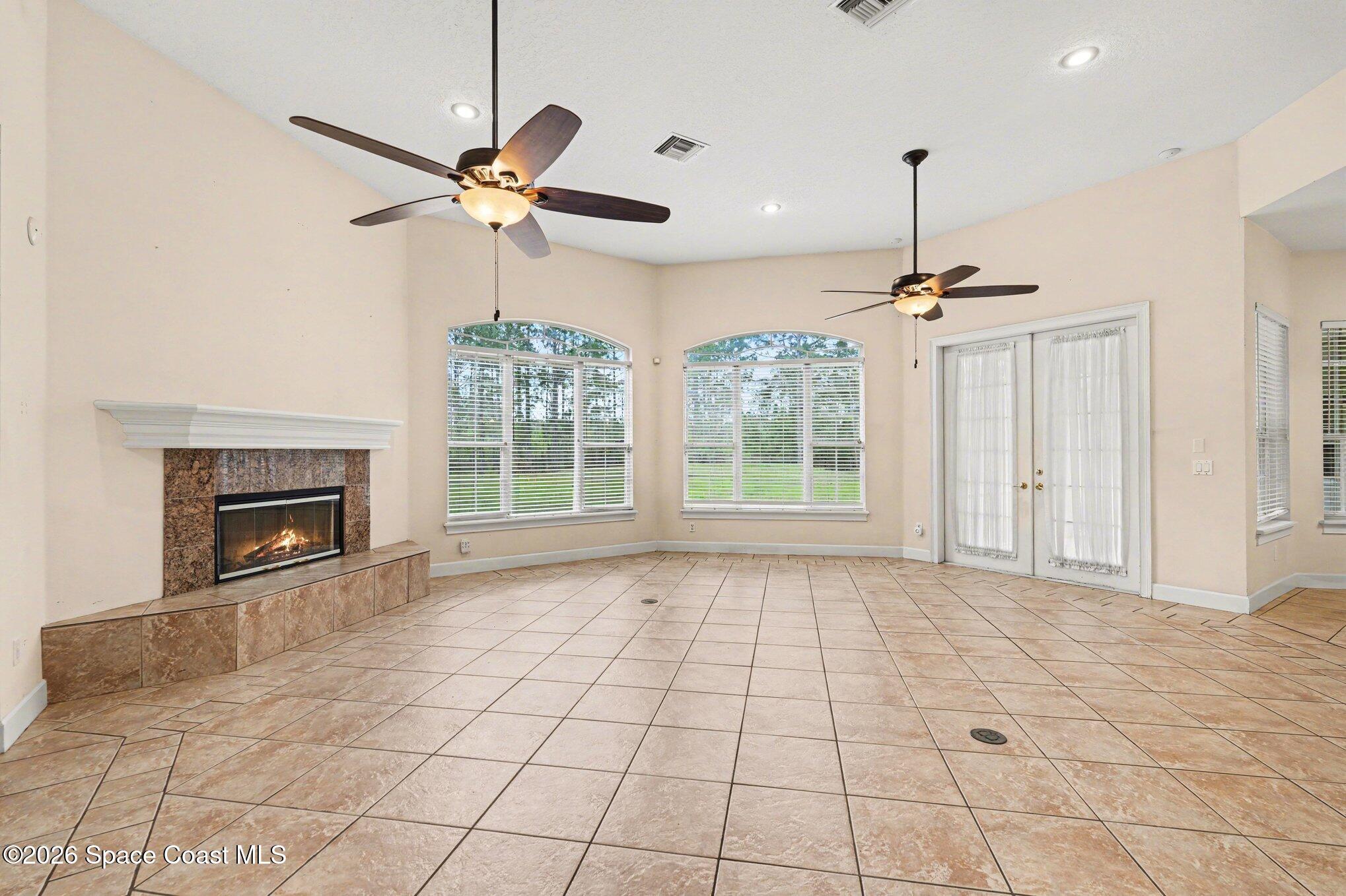 1399 Snapping Turtle Road Mims, FL 32754 - Photo 9 of 51 a view of an empty room with a fireplace and a chandelier fan