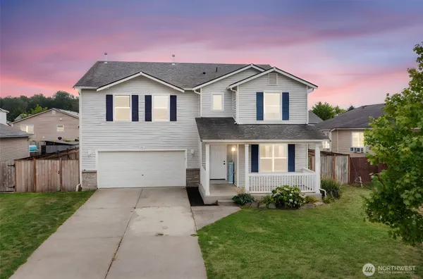 a front view of a house with a yard and garage
