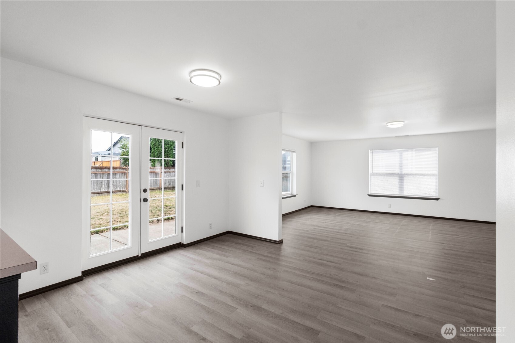 116 Mazza Street Northeast Orting, WA 98360 - Photo 11 of 39 an empty room with wooden floor and windows