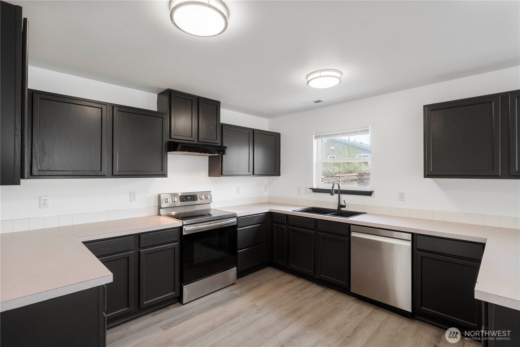 116 Mazza Street Northeast Orting, WA 98360 - Photo 12 of 39 a kitchen with stainless steel appliances granite countertop a sink stove and refrigerator
