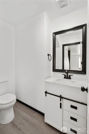 a bathroom with a toilet sink and mirror