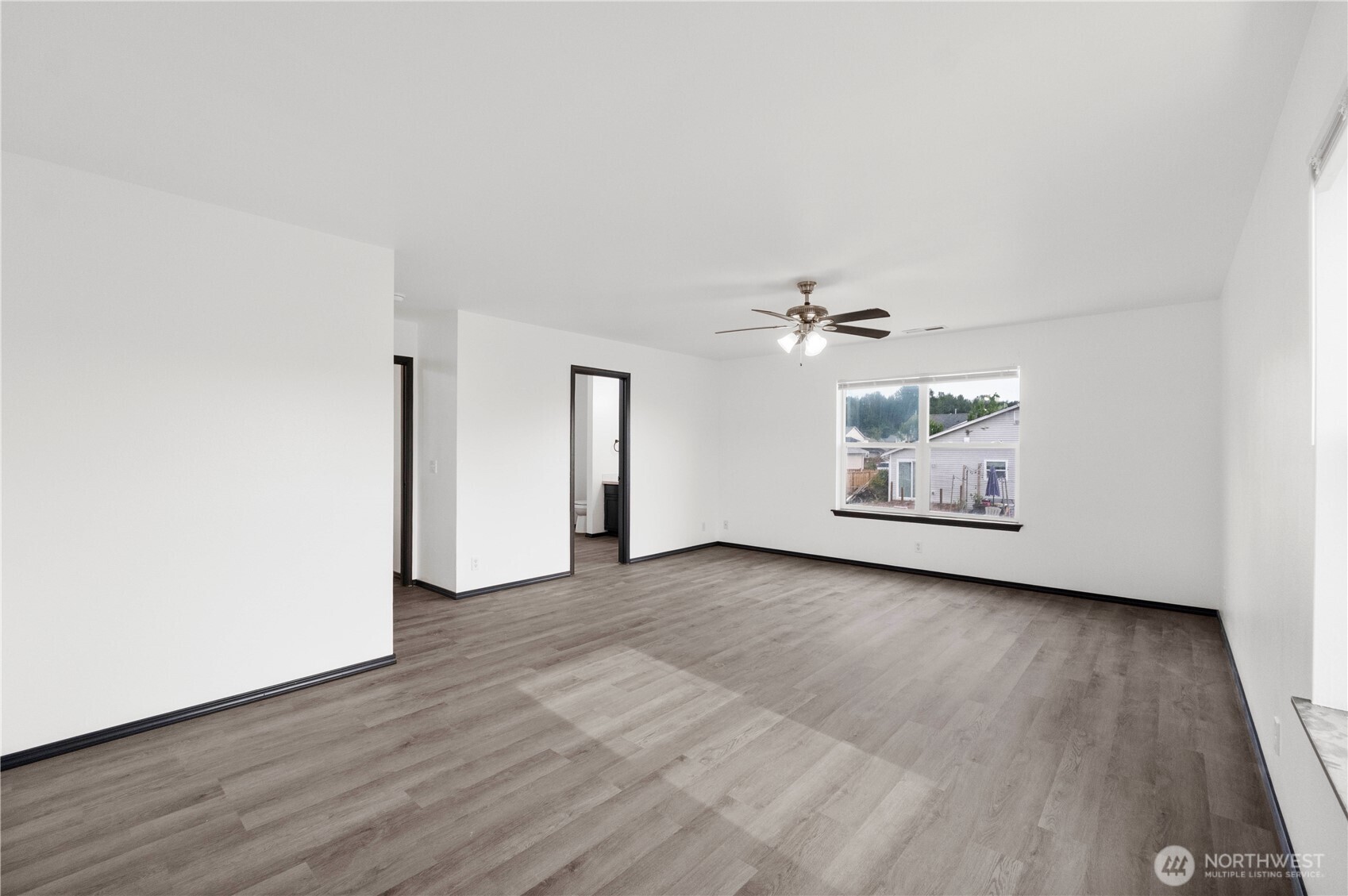 116 Mazza Street Northeast Orting, WA 98360 - Photo 23 of 39 an empty room with wooden floor ceiling fan and window