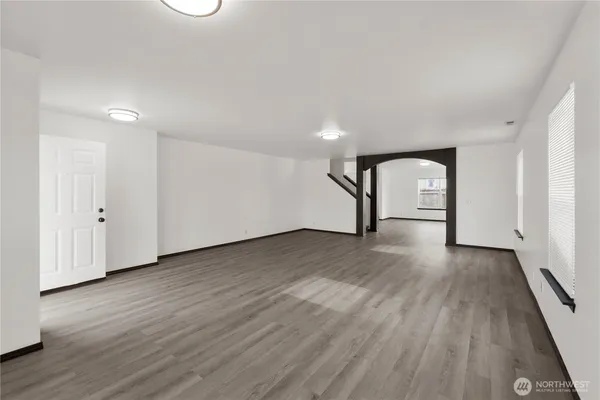 an empty room with wooden floor and mirror