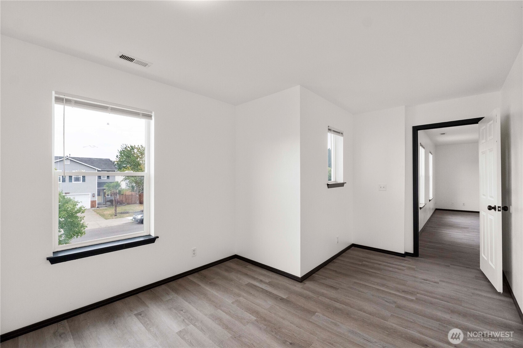 116 Mazza Street Northeast Orting, WA 98360 - Photo 31 of 39 a view of an empty room with wooden floor and a window