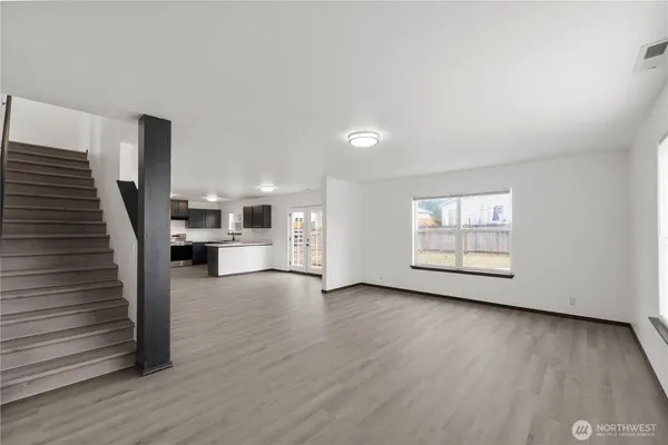 a view of a livingroom with wooden floor and stairs