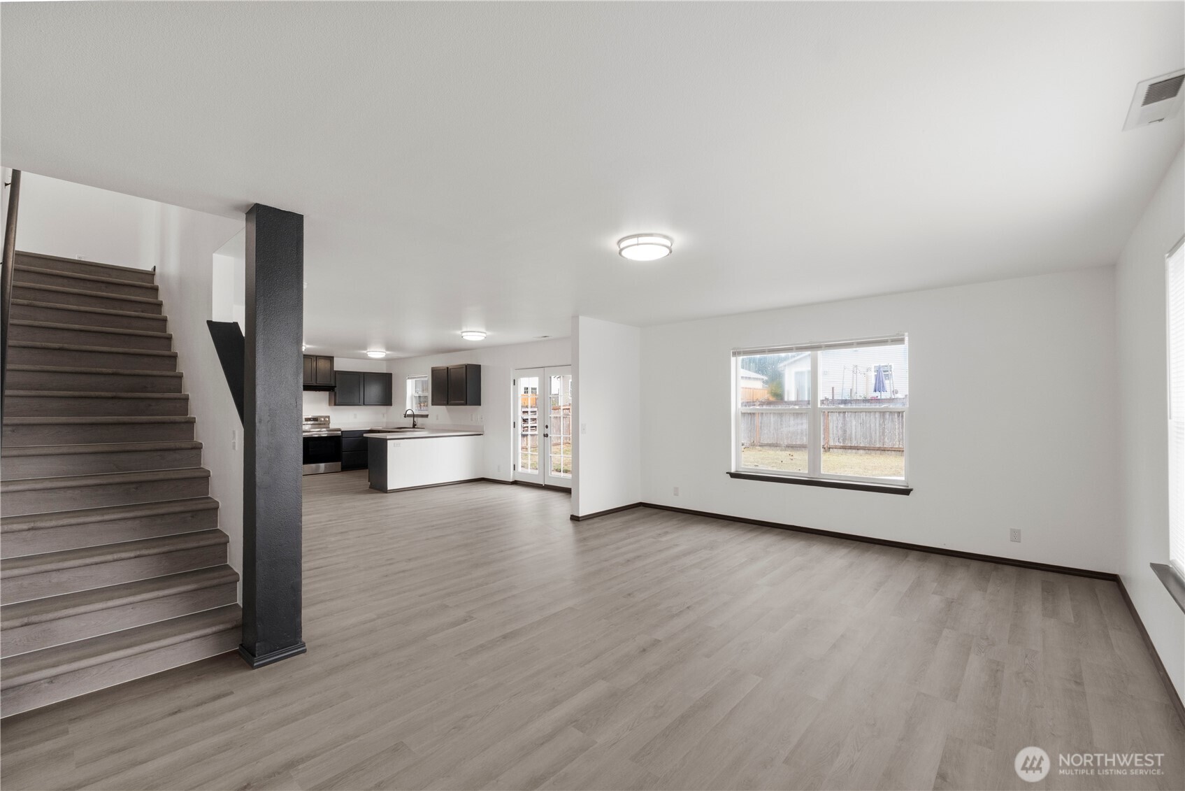 116 Mazza Street Northeast Orting, WA 98360 - Photo 5 of 39 a view of a livingroom with wooden floor and stairs