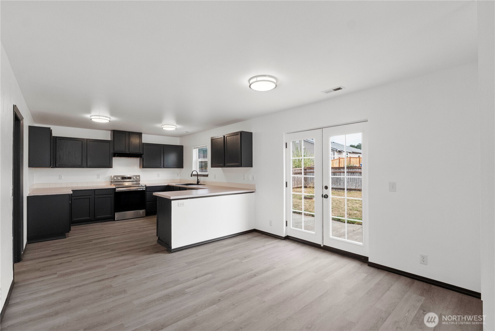 116 Mazza Street Northeast Orting, WA 98360 - Photo 9 of 39 a large kitchen with a lot of counter space and wooden floor
