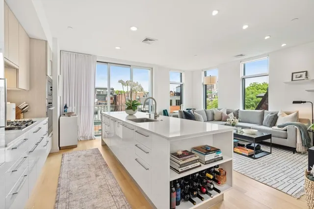 a large kitchen with stainless steel appliances kitchen island granite countertop a sink and cabinets