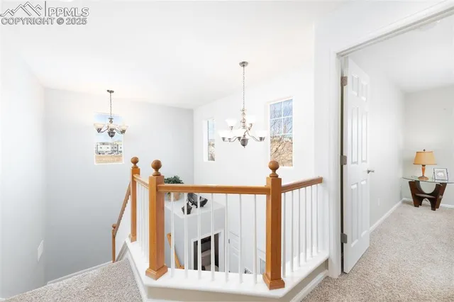 a view of a hallway to a livingroom with furniture